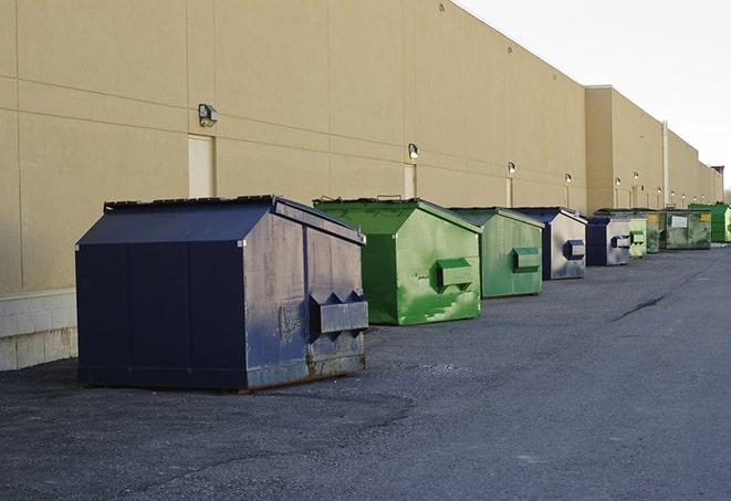 a pile of demolition waste sits beside a dumpster in a parking lot in Grantville